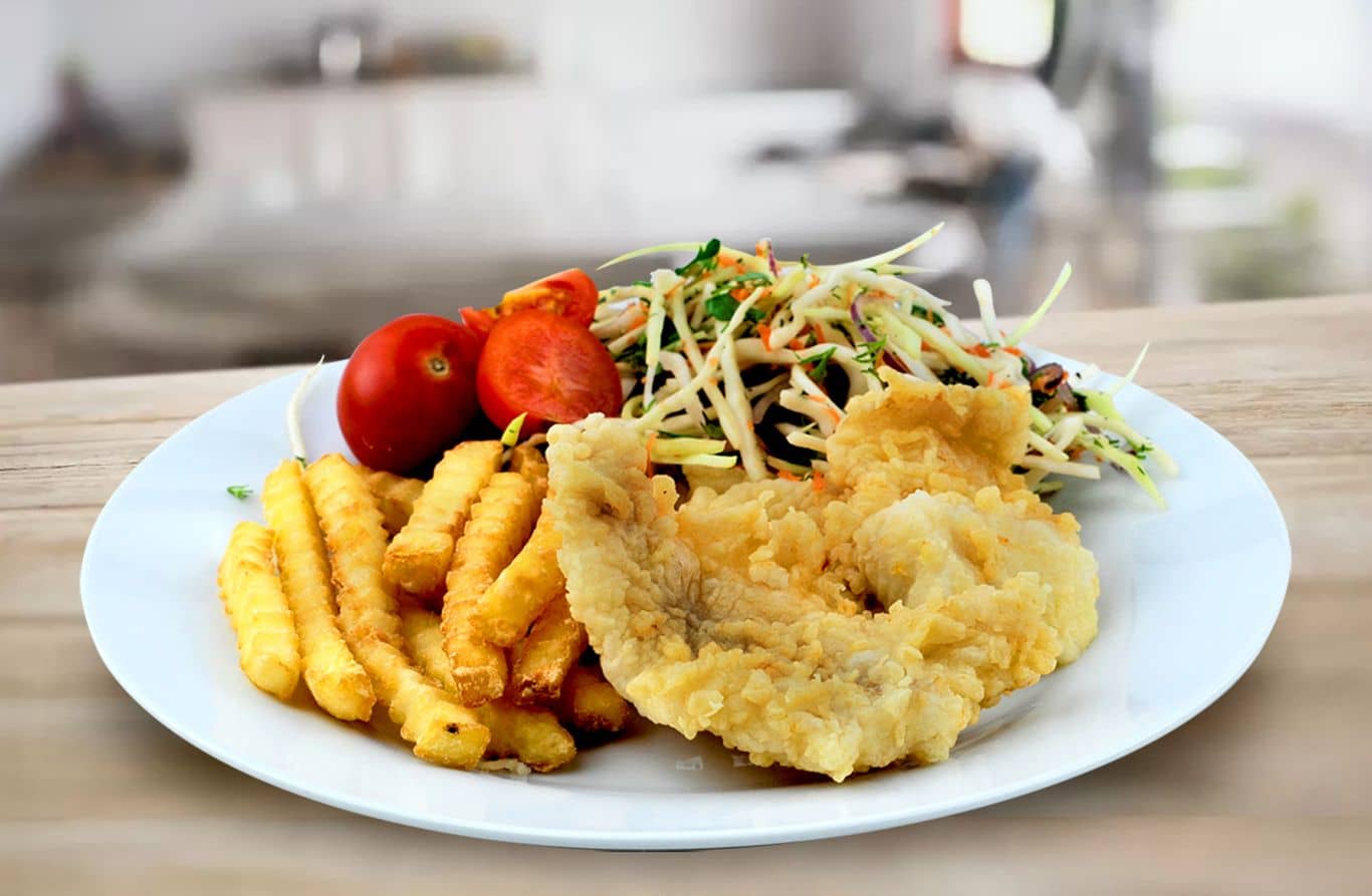 Coated whiting with potato chips and salad